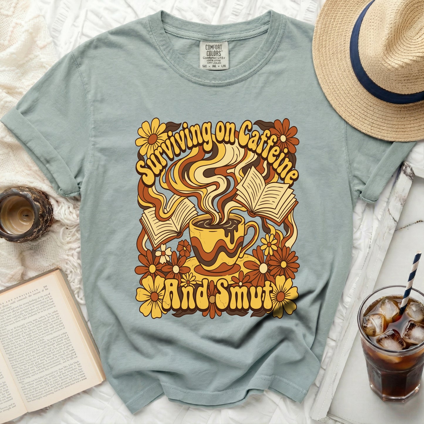 "Surviving on Caffeine And Smut" graphic tee with coffee, books, and flowers.