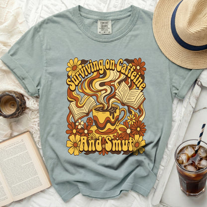 "Surviving on Caffeine And Smut" graphic tee with coffee, books, and flowers.