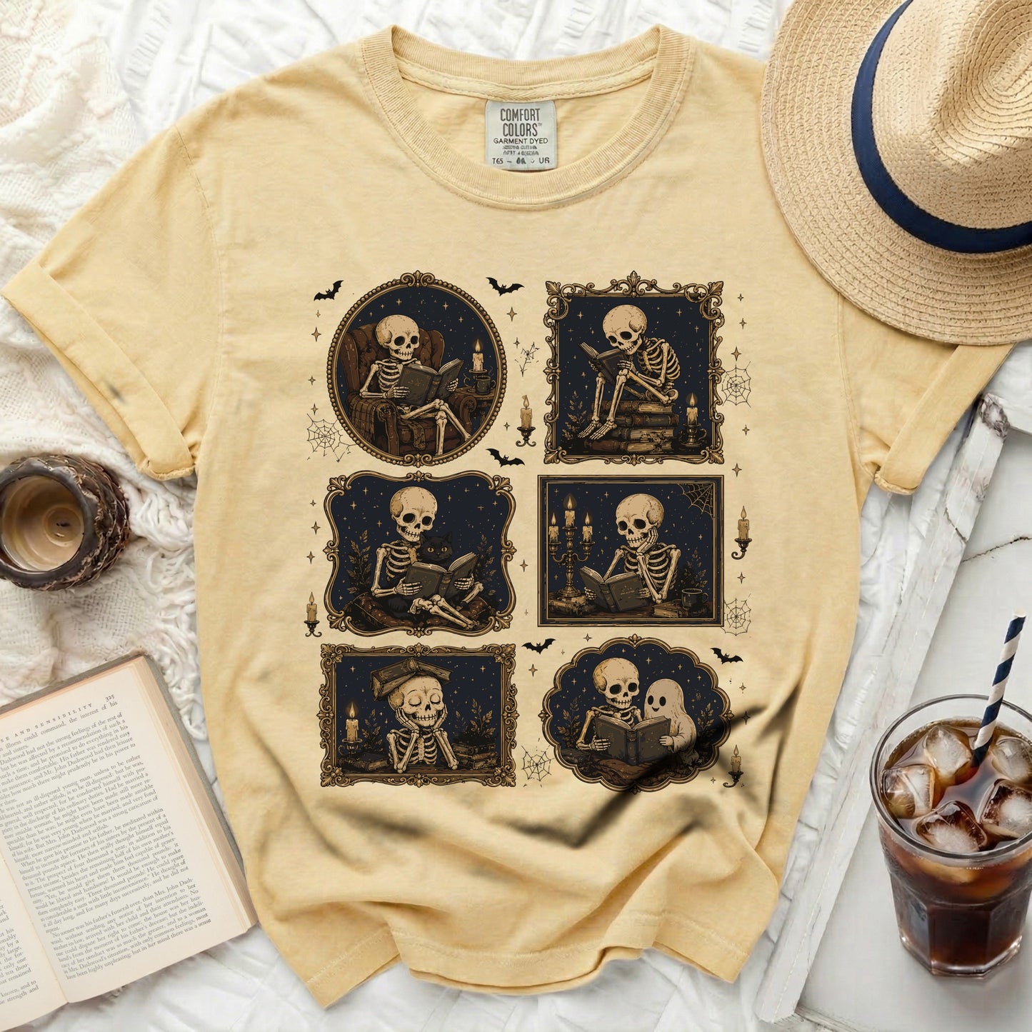 Yellow t-shirt with a graphic of skeletons reading books in ornate frames.