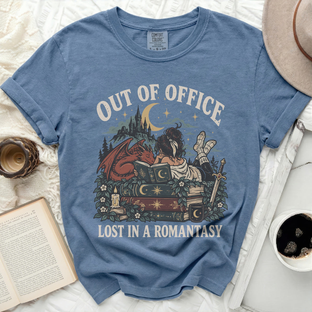 Blue t-shirt with "OUT OF OFFICE LOST IN A ROMANTASY" text and fantasy art.