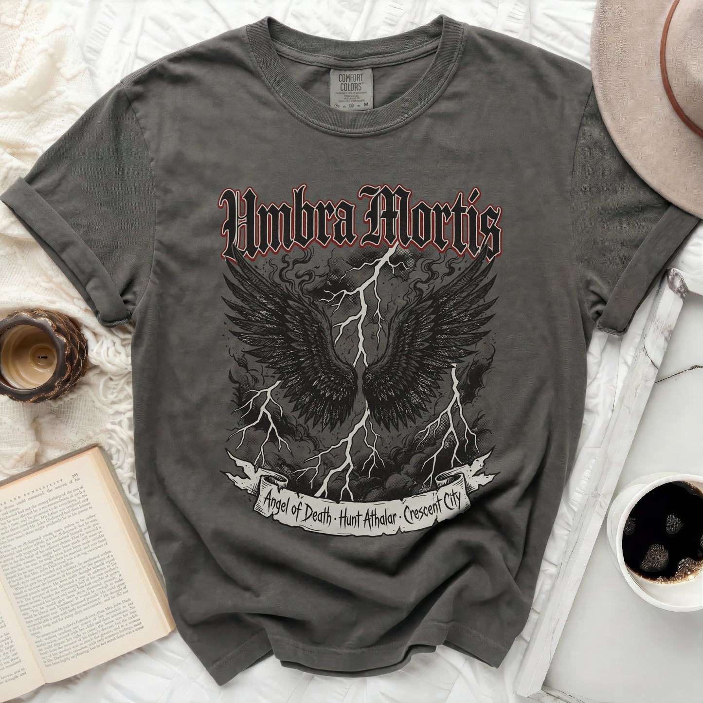 Dark grey t-shirt with "Umbra Mortis" and wings graphic.