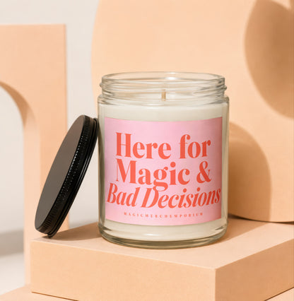 Glass candle with pink label reading "Here for Magic & Bad Decisions"