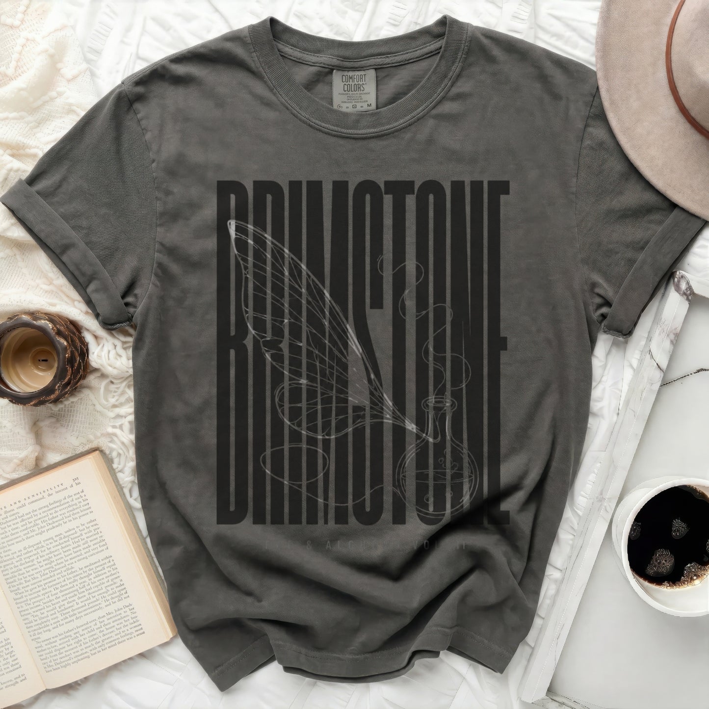 Dark gray t-shirt with "BRIMSTONE" text and a winged potion bottle graphic.