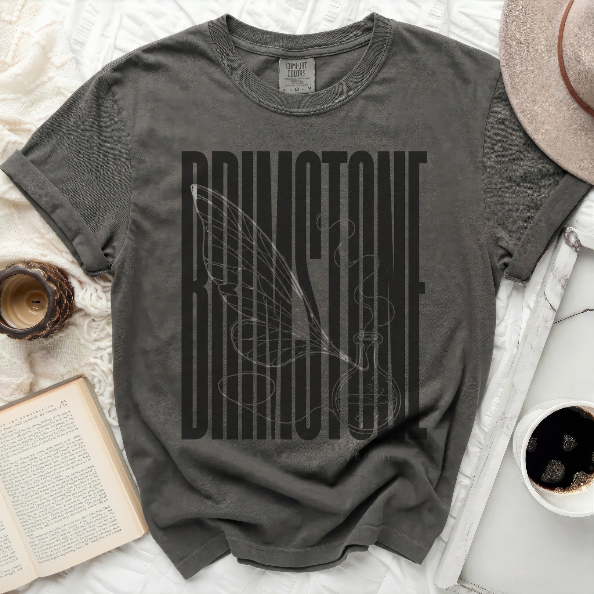 Dark gray t-shirt with "BRIMSTONE" text and a winged potion bottle graphic.