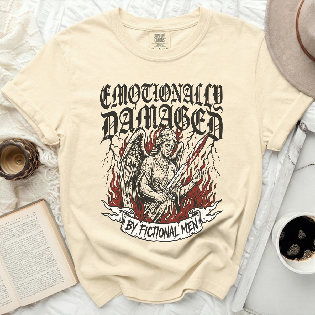 Cream t-shirt with "Emotionally Damaged by Fictional Men" and angel graphic.