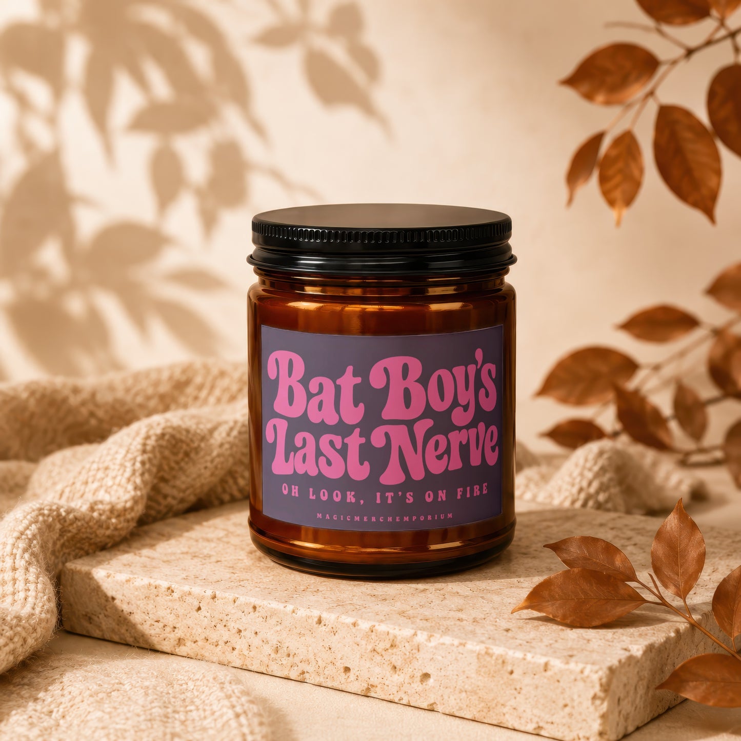 Amber candle jar with purple label reading "Bat Boy's Last Nerve. Oh Look, It's On Fire".