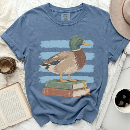 Mallard duck standing on stack of books with blue stripes background.