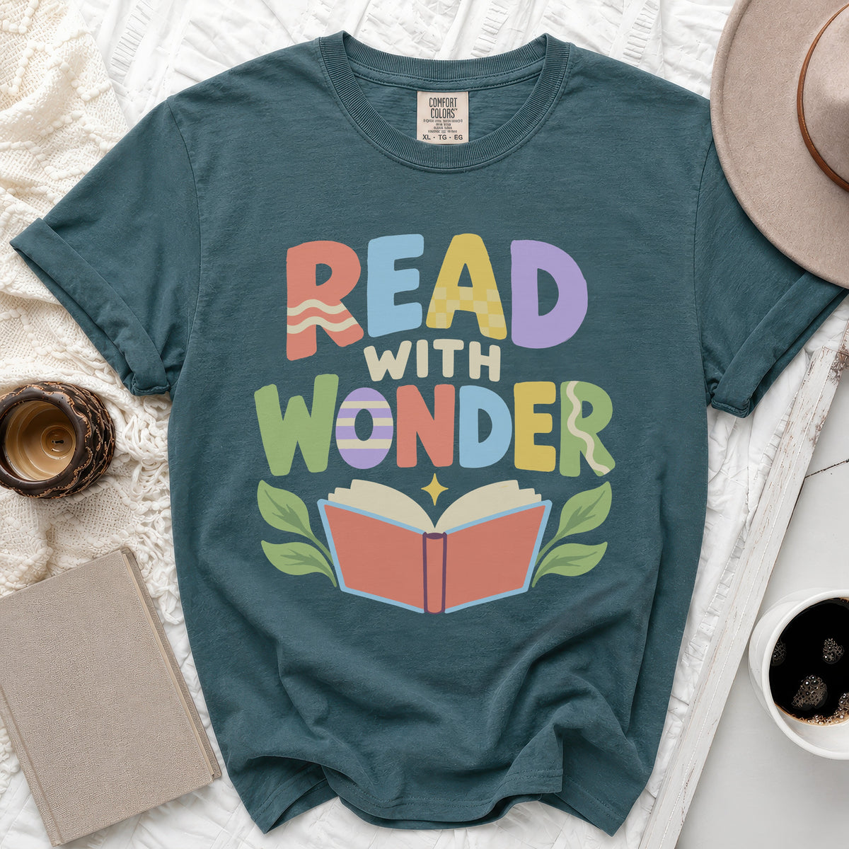 Teal t-shirt with colorful "Read With Wonder" text and an open book graphic.