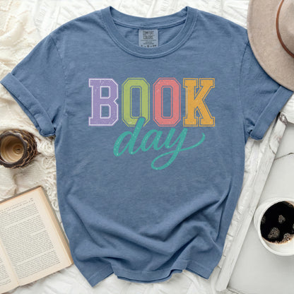 Blue Comfort Colors t-shirt with "BOOK DAY" text in colorful block letters.