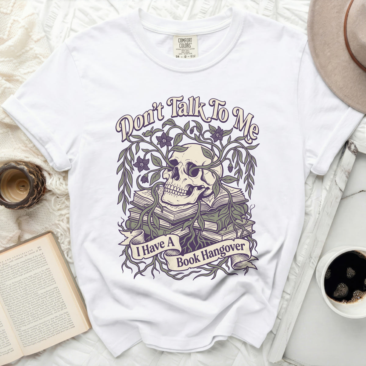 White t-shirt with a skull, books, vines, and text "Don't Talk To Me I Have A Book Hangover."