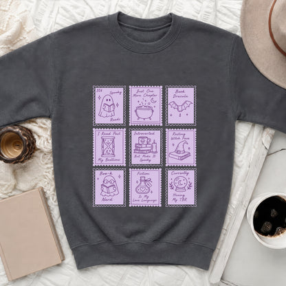 Dark grey sweatshirt with a nine-panel design of ghost, cauldron, bat, and book illustrations.