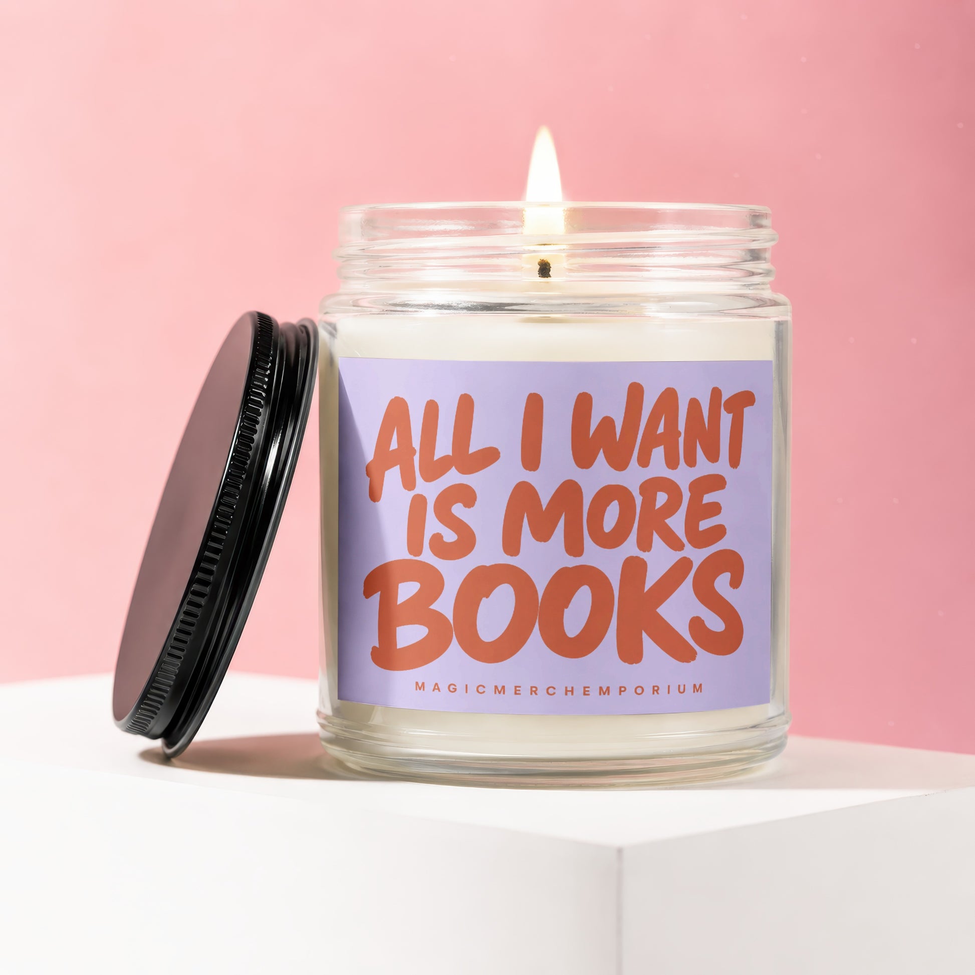Lit jar candle with a purple label that says "ALL I WANT IS MORE BOOKS".