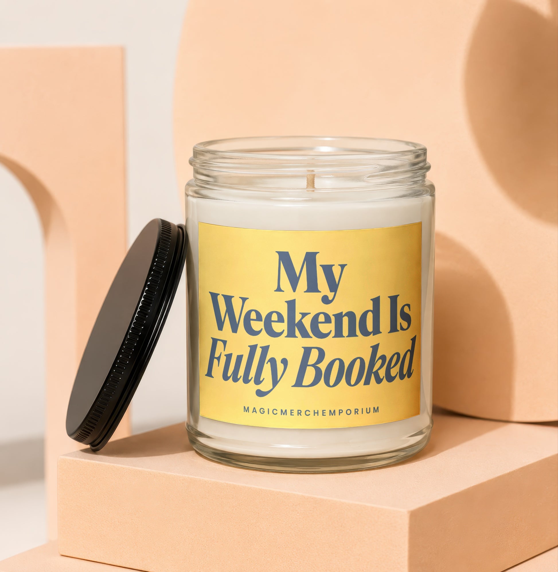 Scented candle with dark blue text "My Weekend Is Fully Booked" on yellow label.