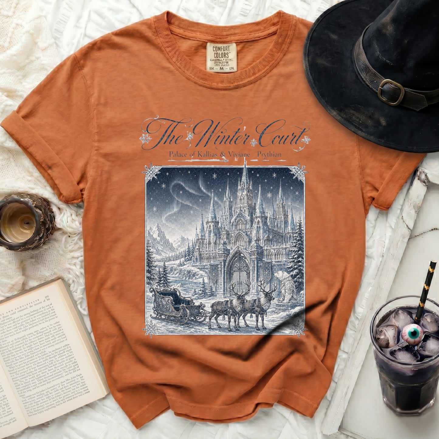 Orange t-shirt with "The Winter Court" and a castle scene featuring reindeer and a sleigh.