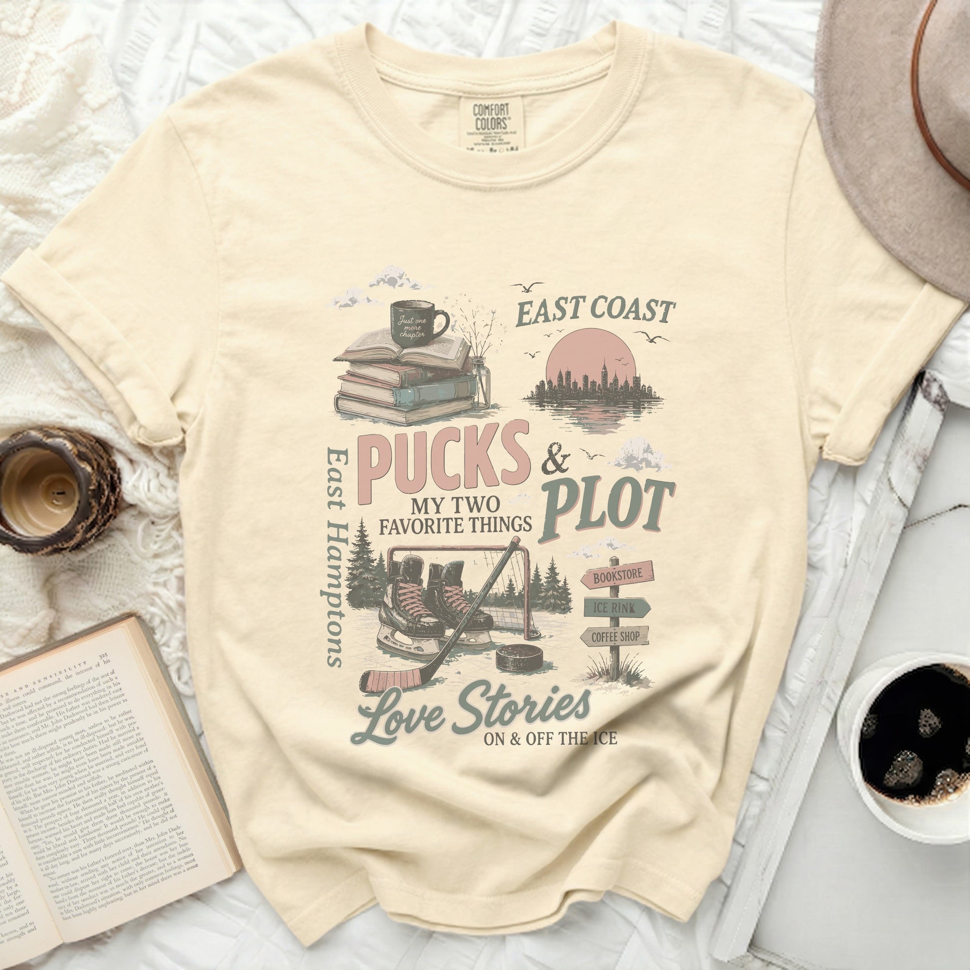 Cream t-shirt with East Coast Pucks and Plot graphic featuring ice skates and books.