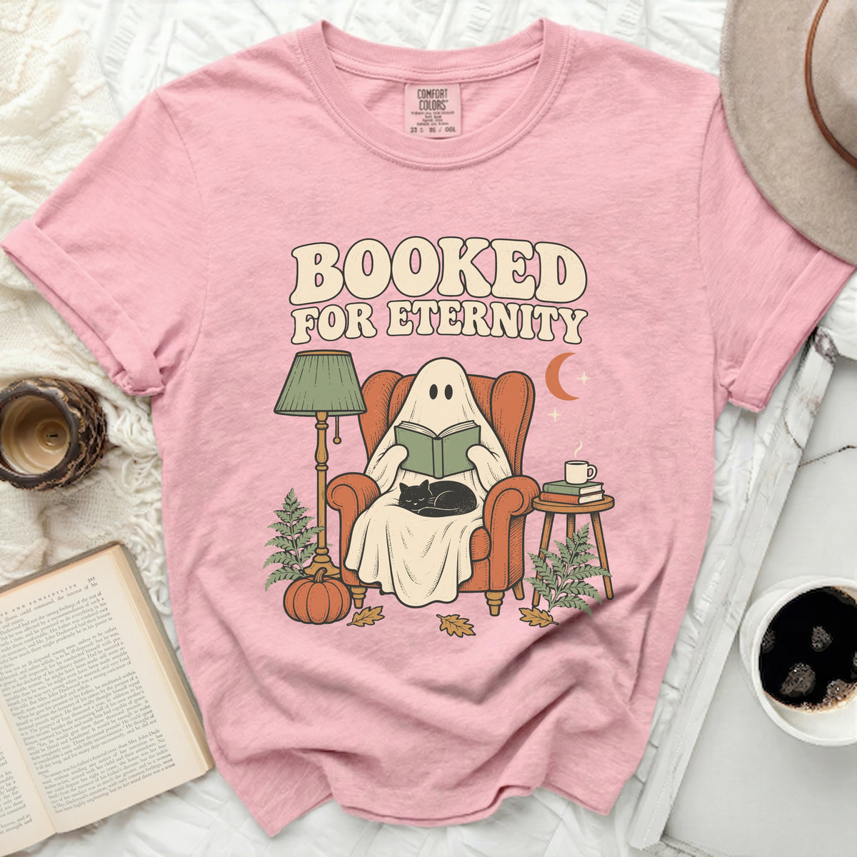 Ghost in armchair reading with cat, "Booked for Eternity" text.