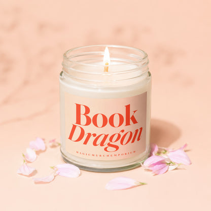 Lit glass jar candle with "Book Dragon" and "MagicMerchEmporium" text on label.