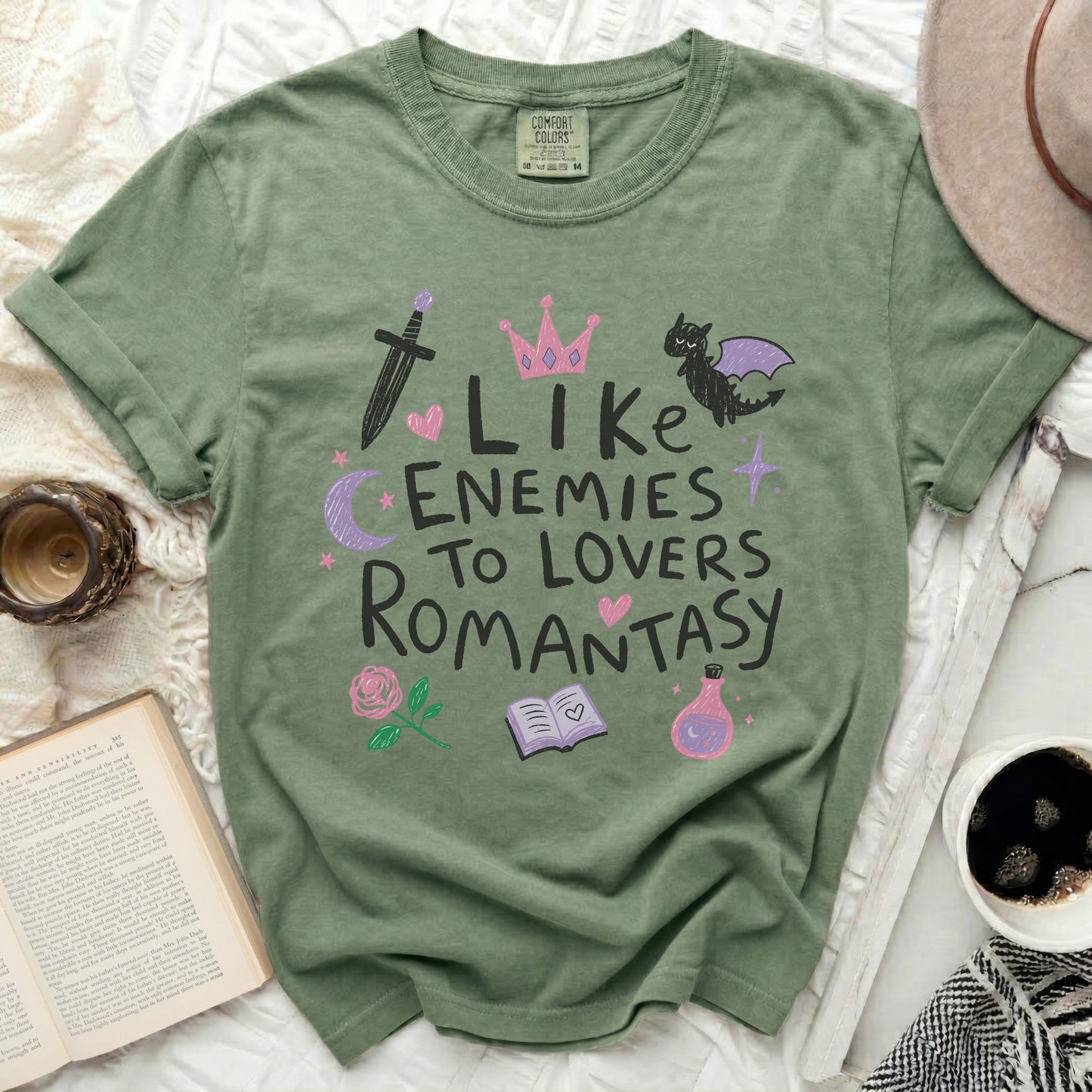 Olive green t-shirt with "Like Enemies To Lovers Romantasy" graphic and icons.