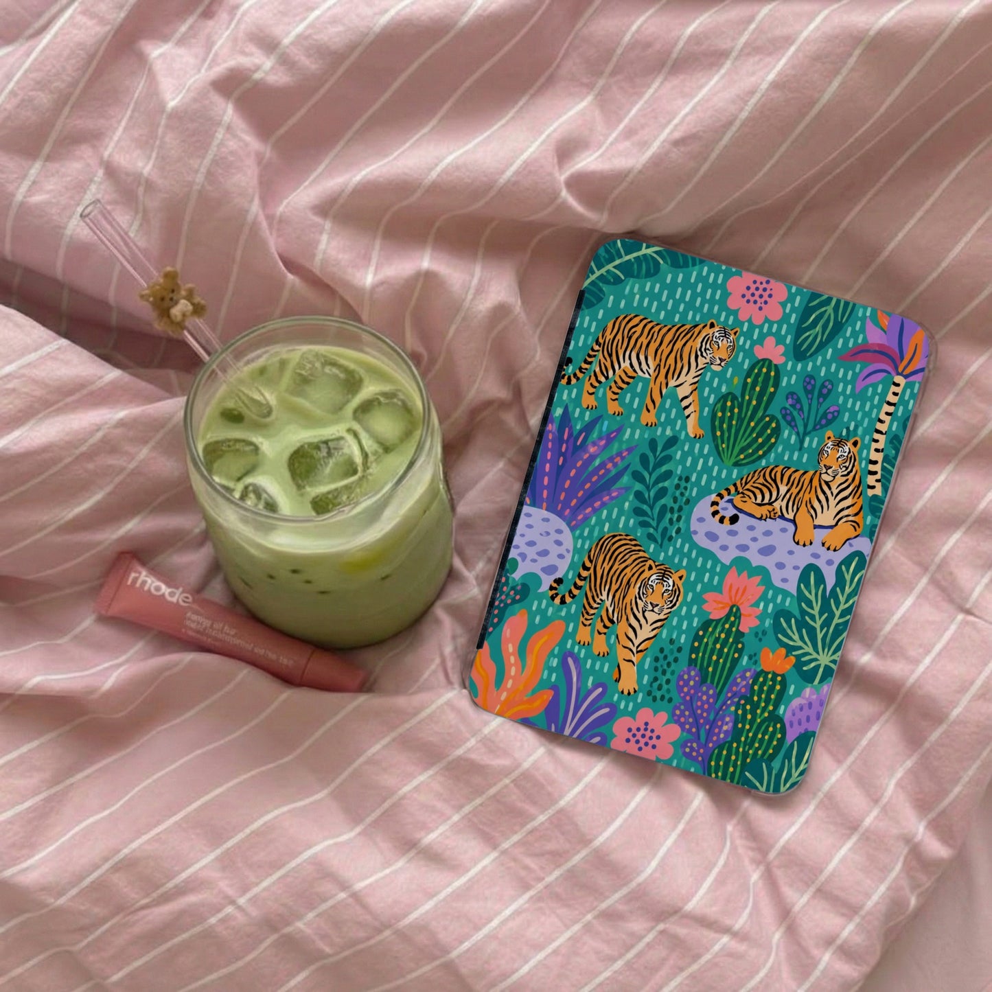 Phone case with tigers and tropical plants on a pink striped background.