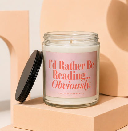 Candle with pink label reading "I'd Rather Be Reading... Obviously."