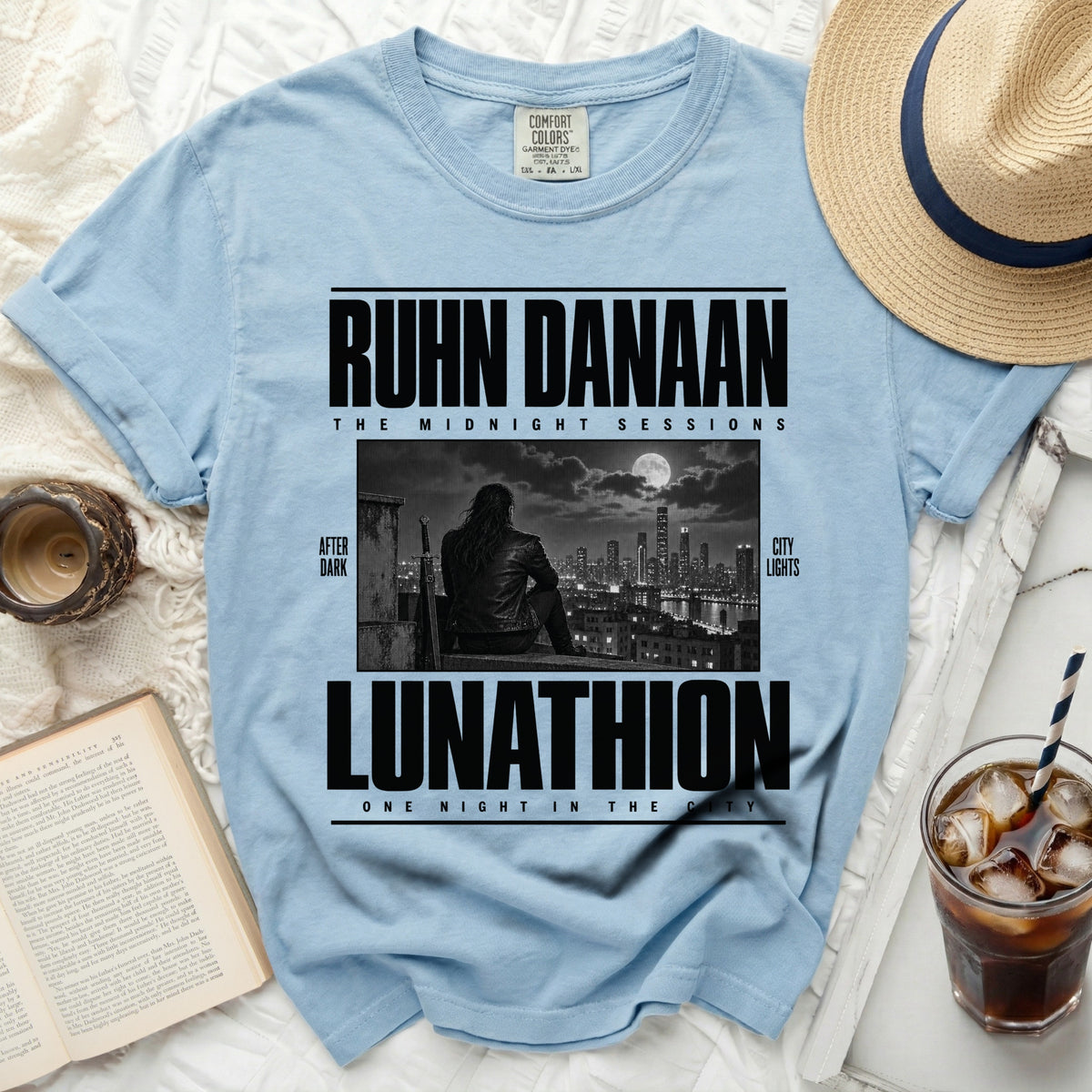 Light blue t-shirt with "RUHN DANAAN THE MIDNIGHT SESSIONS LUNATHION ONE NIGHT IN THE CITY" text.