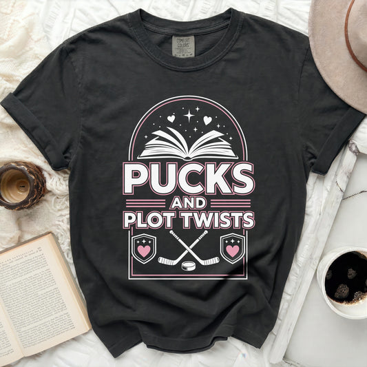 Black t-shirt with "Pucks and Plot Twists" text and hockey graphics.