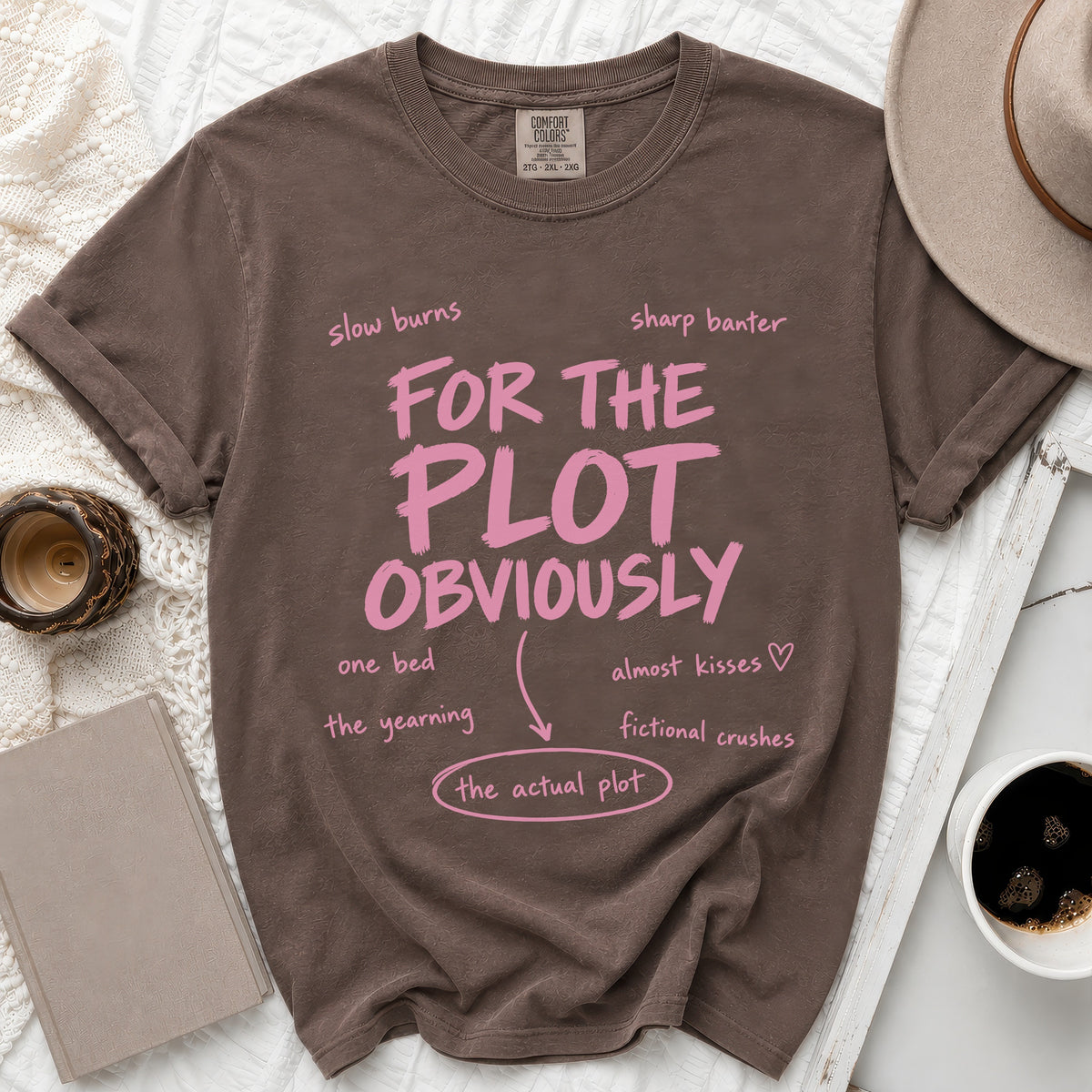 Brown t-shirt with pink text "FOR THE PLOT OBVIOUSLY" and related plot points.