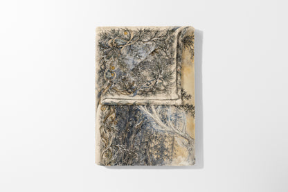 Folded blanket with a detailed illustration of a forest scene featuring a deer.