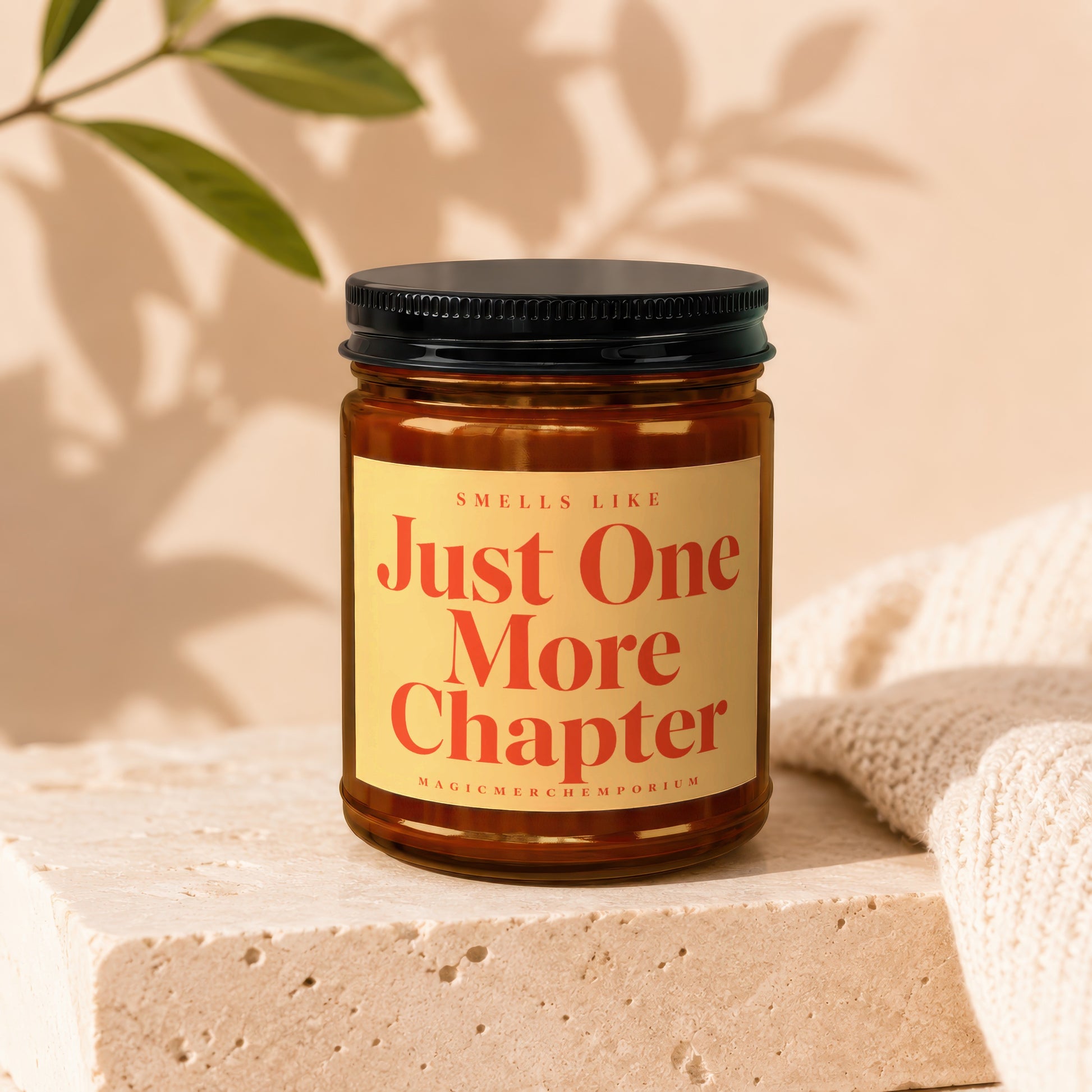 Amber candle with black lid, "Smells Like Just One More Chapter" text.
