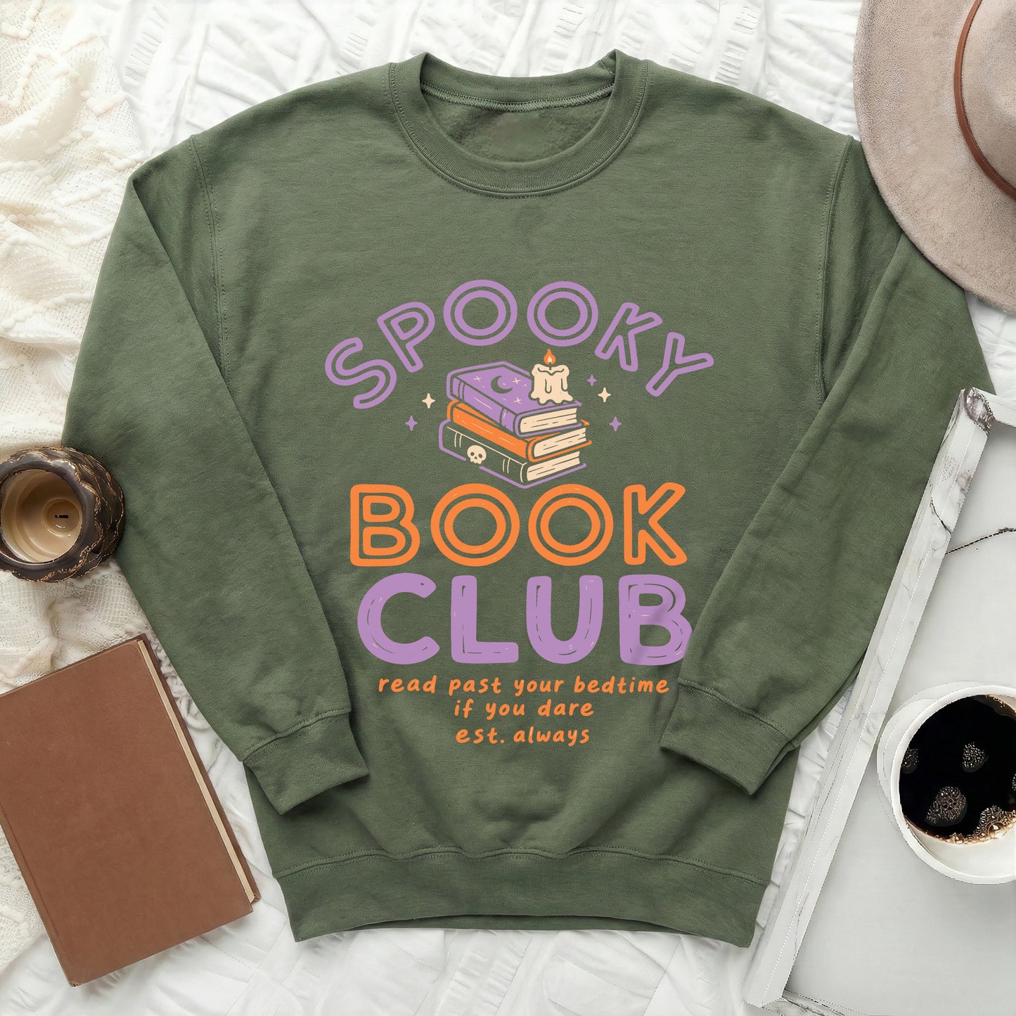 Green sweatshirt with "Spooky Book Club" text and stacked books graphic.