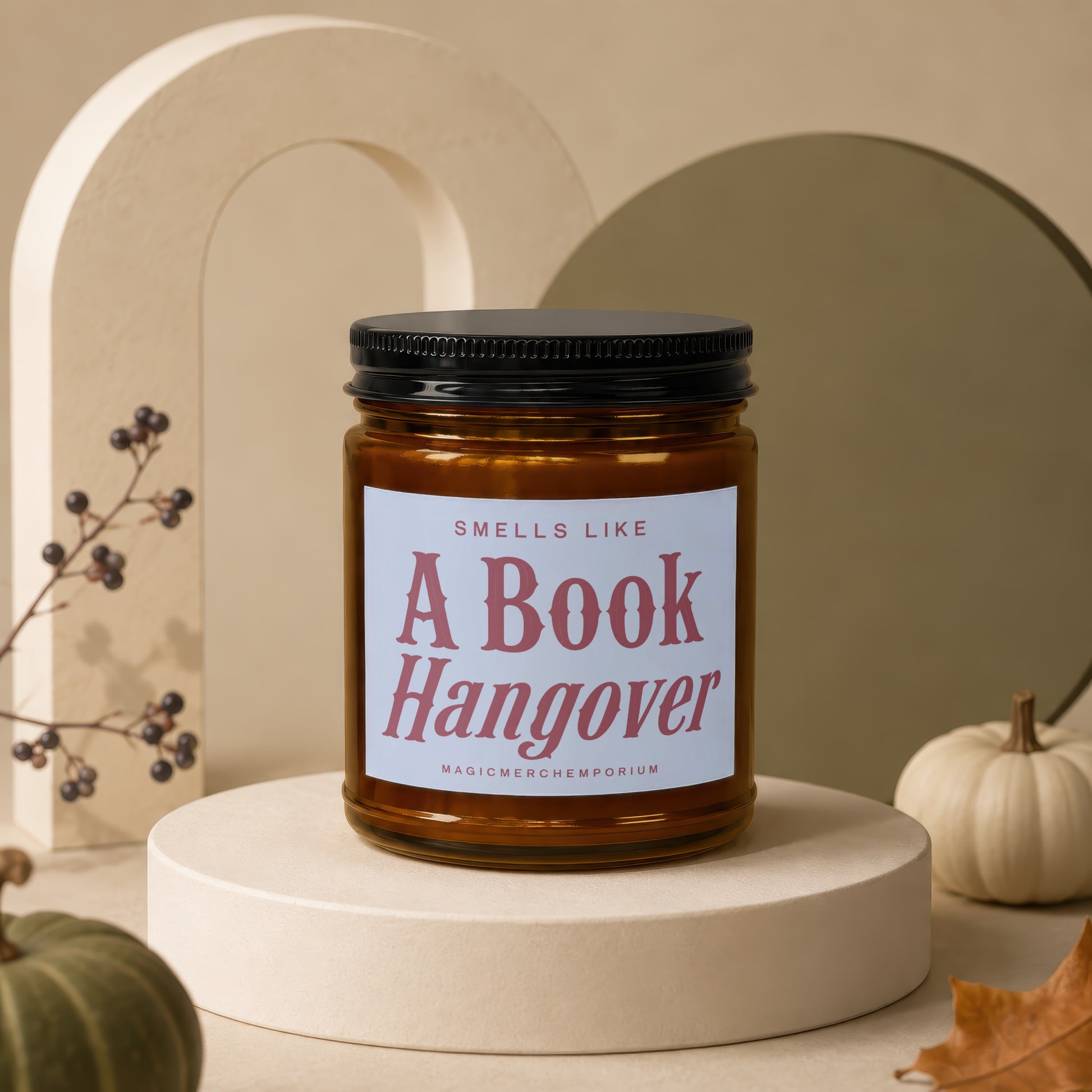 Glass candle with black lid labeled "Smells Like A Book Hangover".