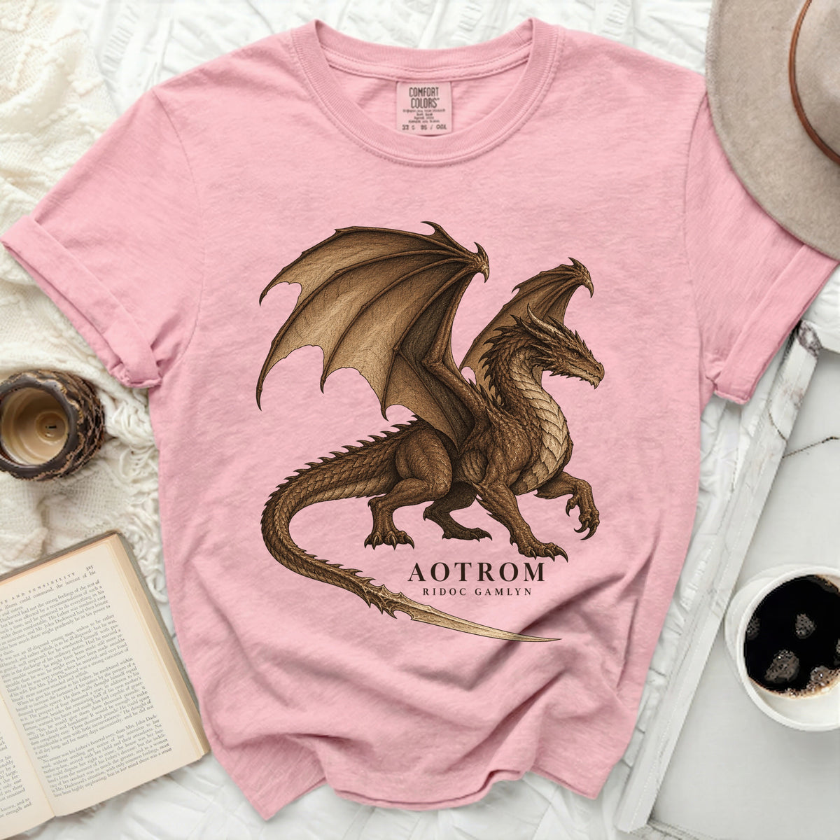 Pink Comfort Colors t-shirt featuring a brown dragon graphic with text "AOTROM RIDOC GAMLYN".