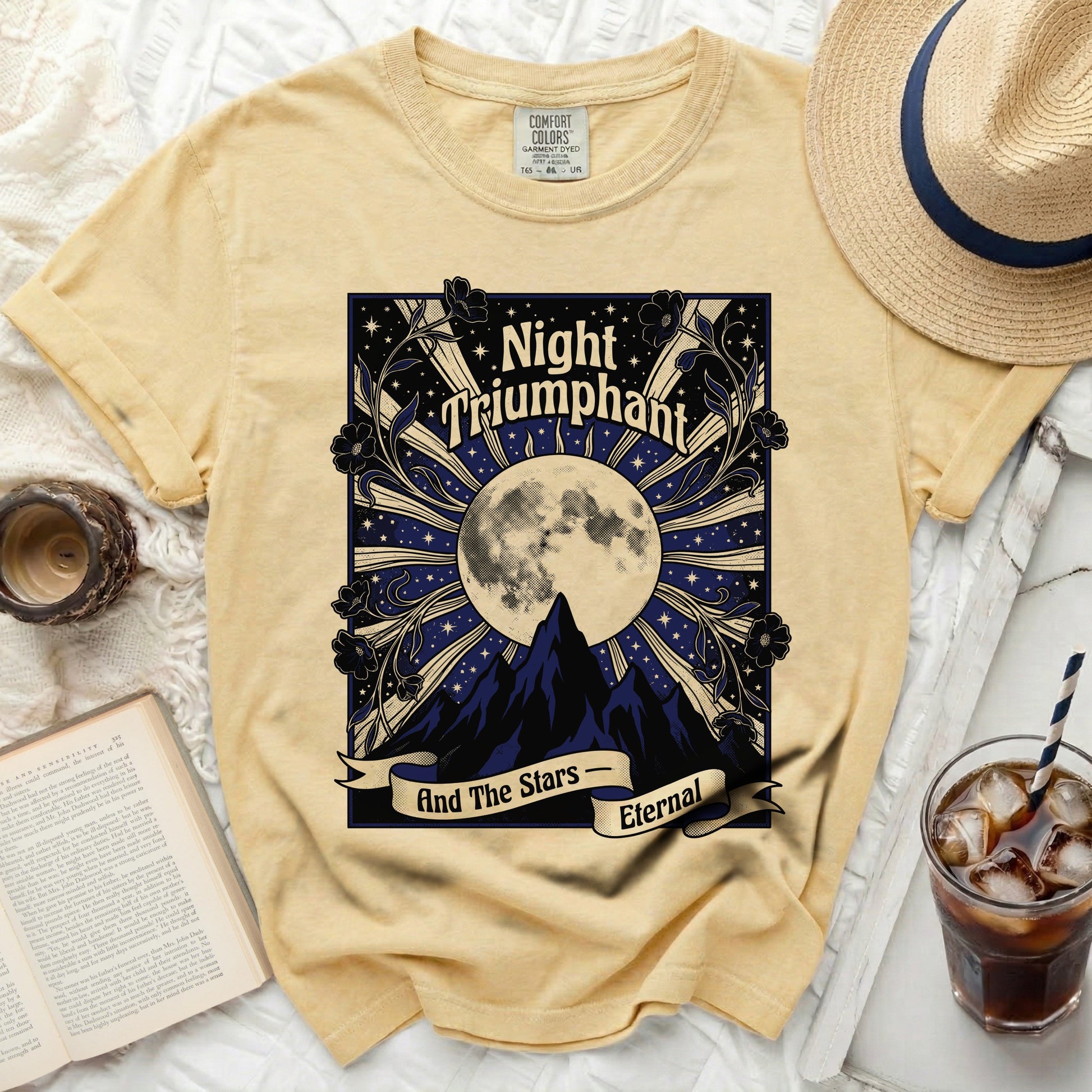 Yellow t-shirt with "Night Triumphant" and moon over mountains graphic.