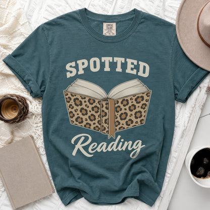 Teal t-shirt with "Spotted Reading" text and leopard print open book graphic.