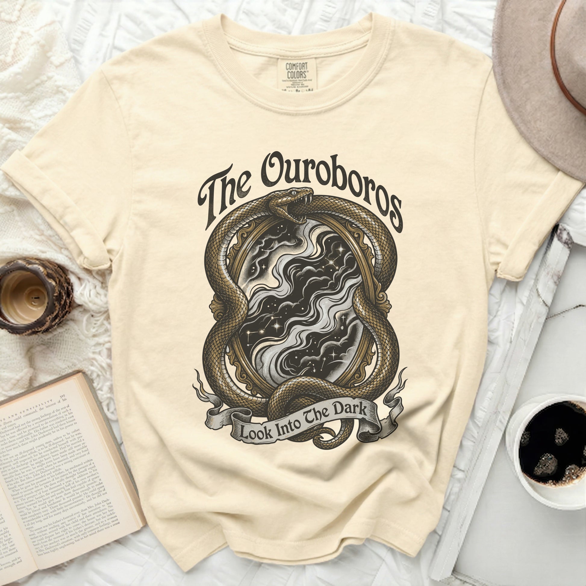 Cream t-shirt with "The Ouroboros" snake and "Look Into The Dark" text.