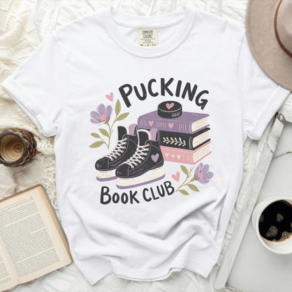 White t-shirt with "Pucking Book Club" text, hockey skates, and flowers.