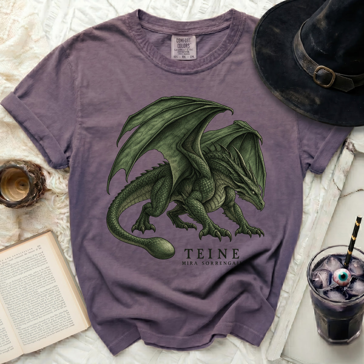 Purple t-shirt with a detailed green dragon graphic and text "TEINE MIRA SORRENGALI".
