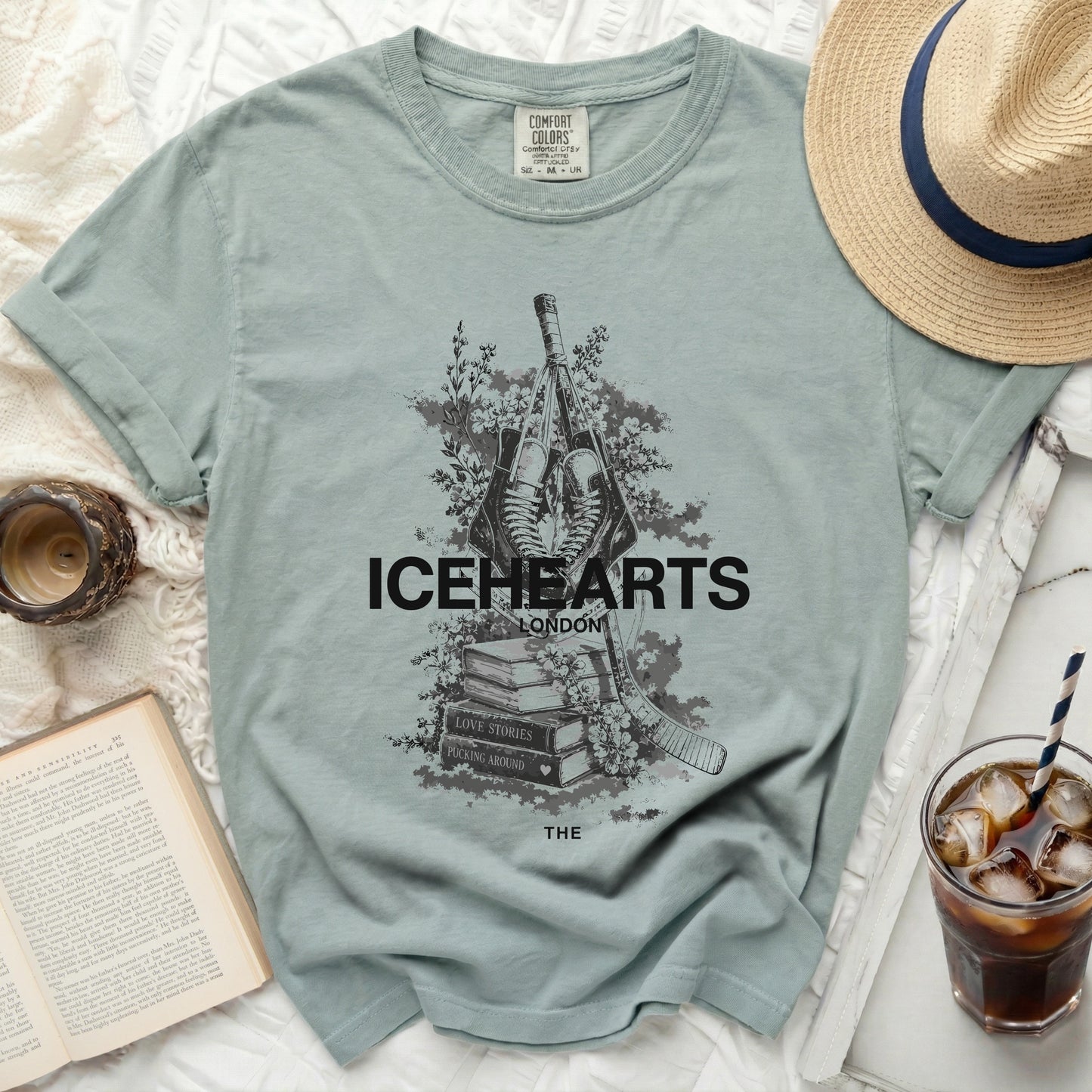 Icehearts London graphic t-shirt with hockey sticks, flowers, and book title.