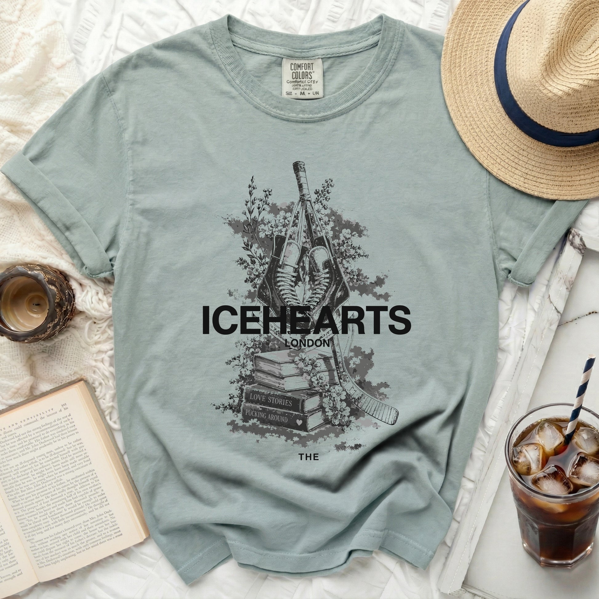 Icehearts London graphic t-shirt with hockey sticks, flowers, and book title.
