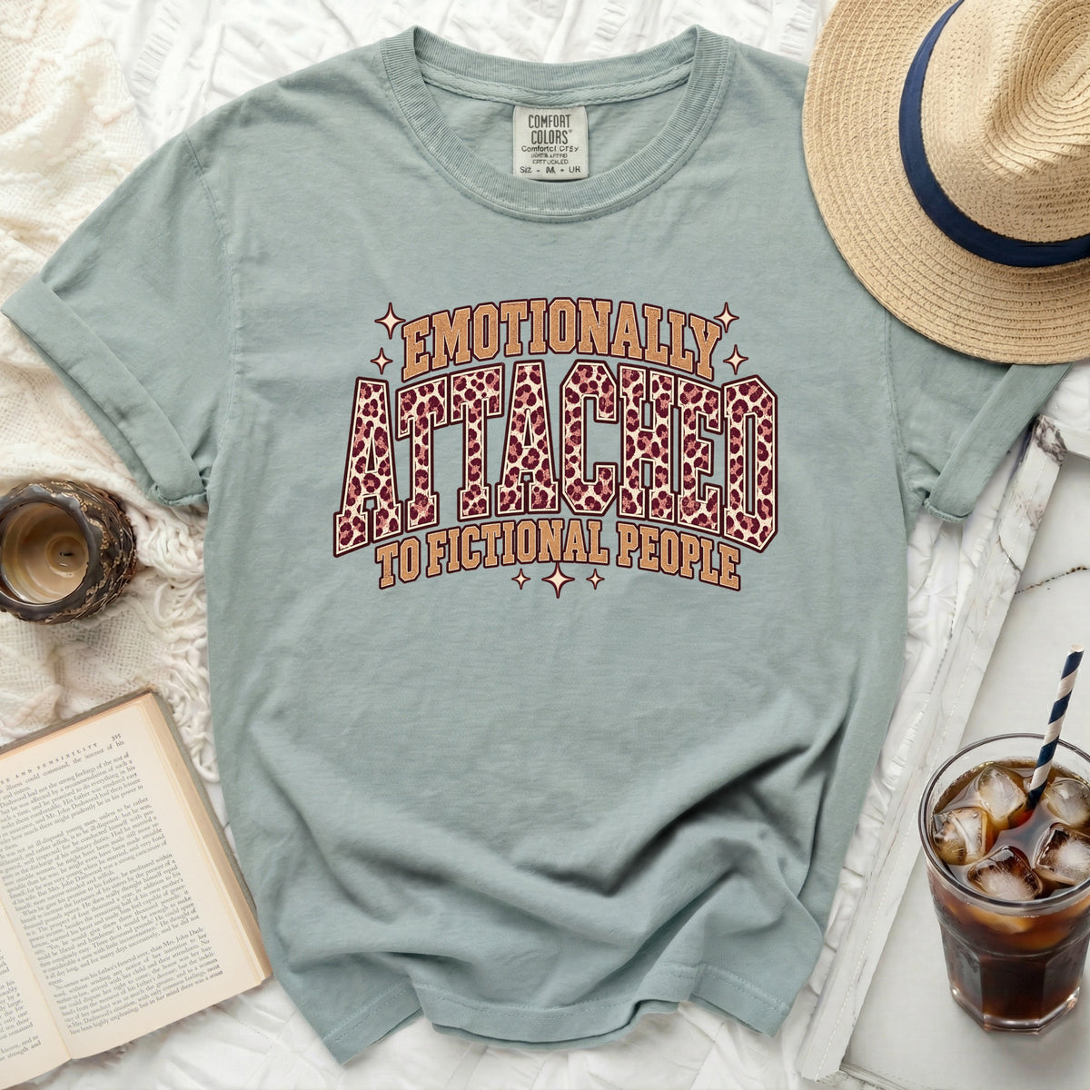 Light blue t-shirt with "Emotionally Attached to Fictional People" leopard print text.