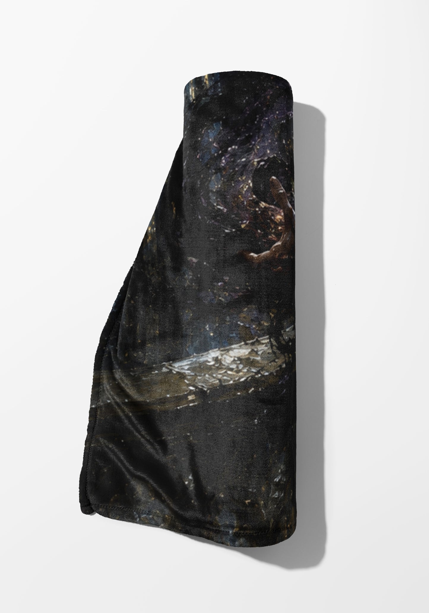 Rolled dark blanket with a starry, textured design and a visible hand.