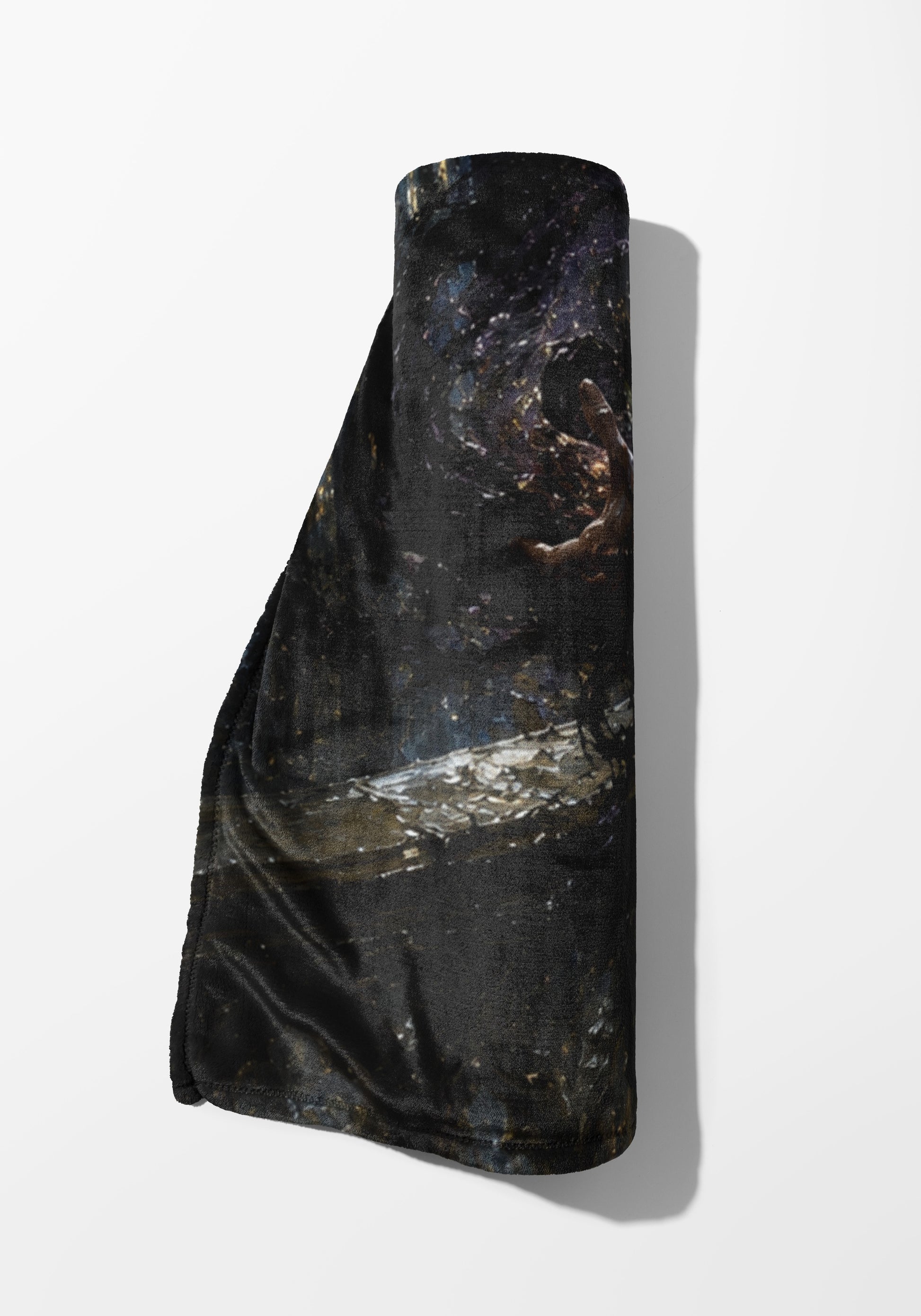 Rolled dark blanket with a starry, textured design and a visible hand.