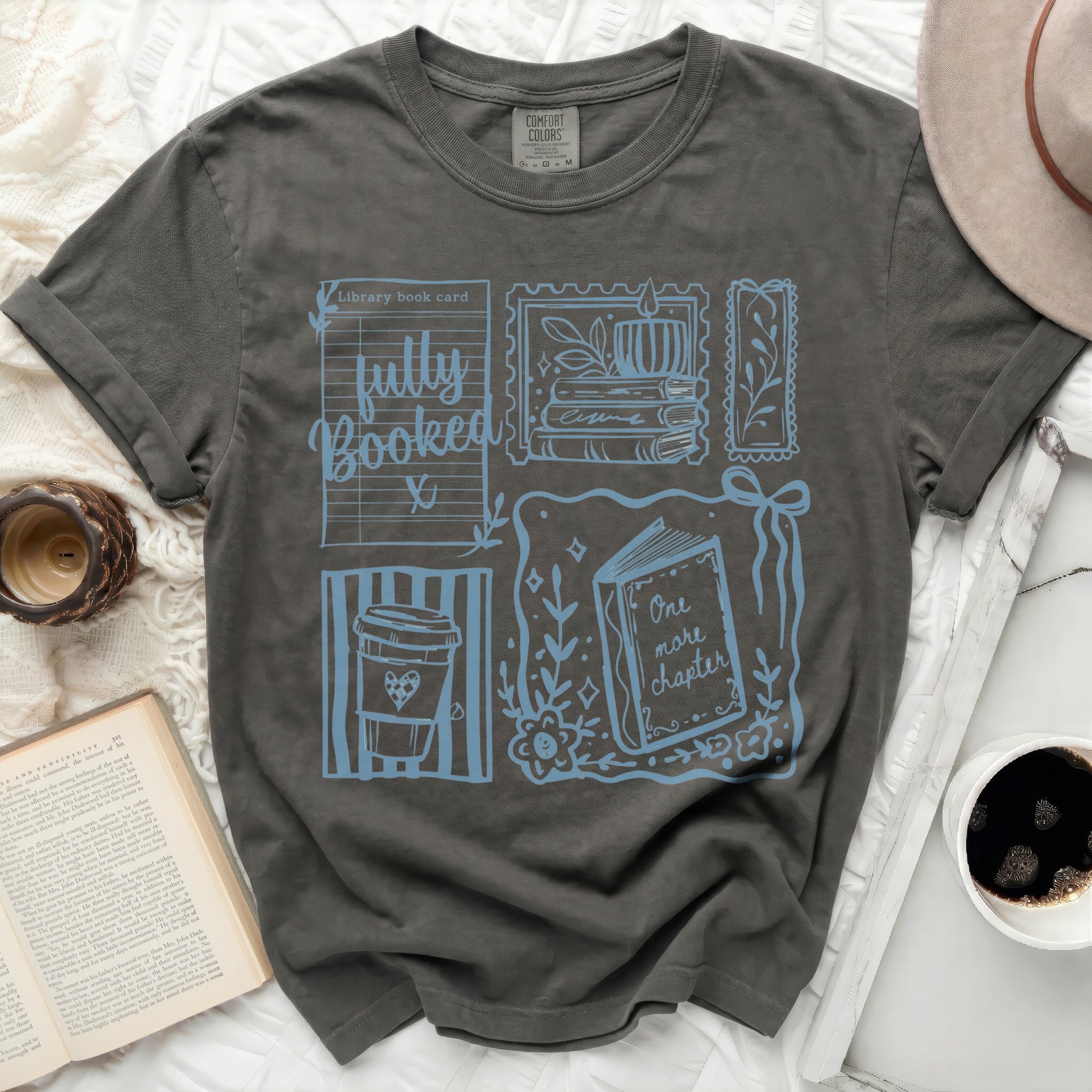 T-shirt with library card design, coffee cup, and book illustrations.