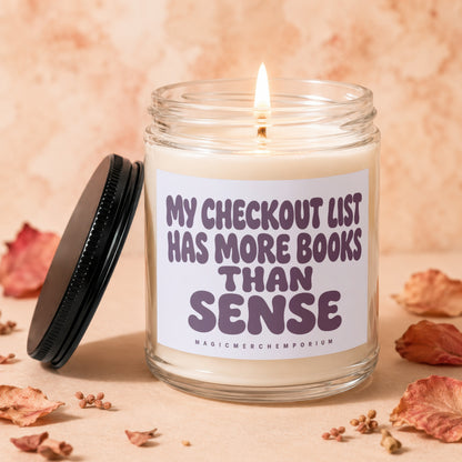 Candle with "MY CHECKOUT LIST HAS MORE BOOKS THAN SENSE" text.