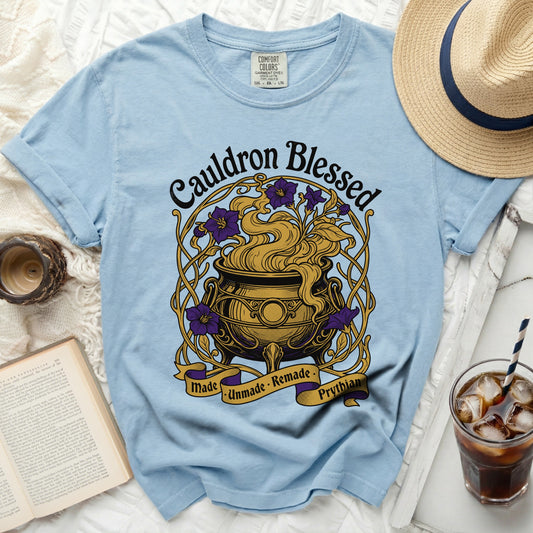 Light blue t-shirt with "Cauldron Blessed" text and a cauldron graphic.