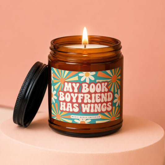Amber jar candle with lit wick and "My Book Boyfriend Has Wings" text.