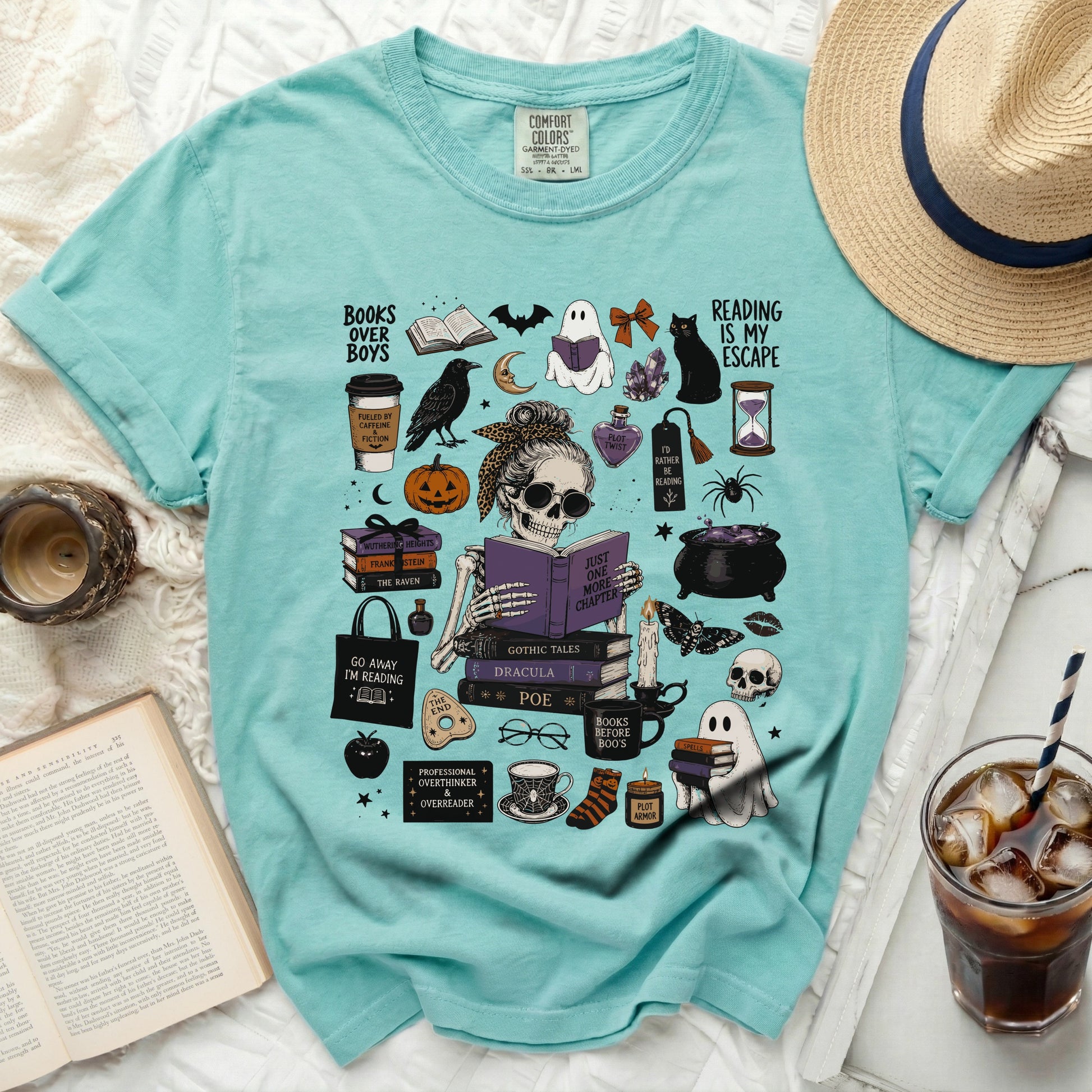 Mint green t-shirt with Halloween and book-themed graphics and text.