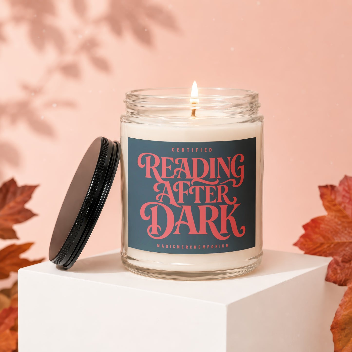 Jar candle with "Certified Reading After Dark" label on pink background with fall leaves.
