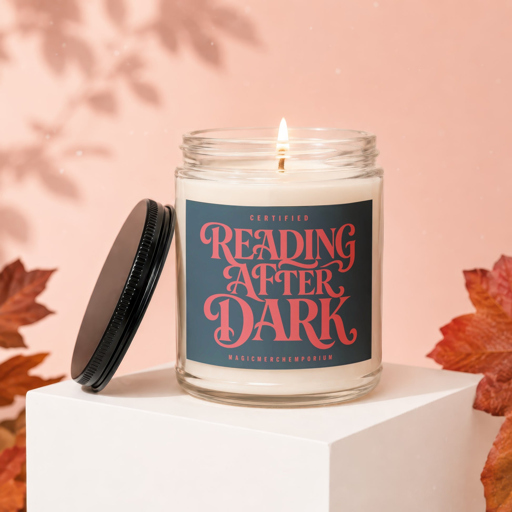Jar candle with "Certified Reading After Dark" label on pink background with fall leaves.