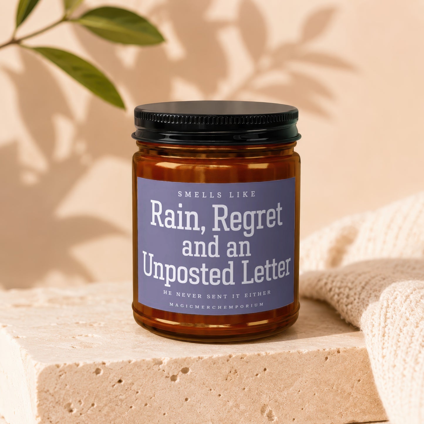 Amber jar candle with purple label reading "Rain, Regret and an Unposted Letter."